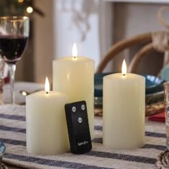 Lot De 3 Bougies Piliers Flamme Réaliste à LED TruGlow® -Éclairage Domestique CA18013 bougies ivoire avec telecommande sur une table festive