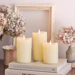 3 Bougies Piliers TruGlow®, Effet Cire Coulante, Avec Télécommande 11 3 Bougies Piliers TruGlow®, Effet Cire Coulante, Avec Télécommande -Éclairage Domestique CA20035 3 bougies piliers a cire coulante sur des livres