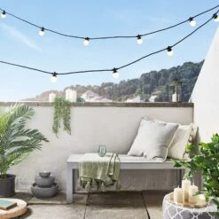 Guirlande Guinguette Pro Connect15m 30 LED Blanc Chaud Câble Noir Raccordable 6 Guirlande Guinguette Pro Connect15m 30 LED Blanc Chaud Câble Noir Raccordable -Éclairage Domestique PR10 2YWB guirlande guinguette pro connect blanc chaud cable noir sur balcon avec fontaine et bougies