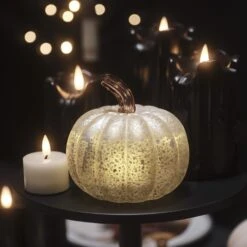 Citrouille Lumineuse En Verre à La Patine Blanche 25 Citrouille Lumineuse En Verre à La Patine Blanche -Éclairage Domestique citrouille lumineuse en verre a la patine blanche sur une table basse